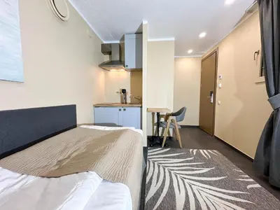 a small room with a bed and a kitchen at New Town Home 1 in Vilnius