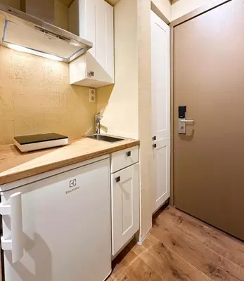 a kitchen with white cabinets and a sink and a door at New Town Home 1 in Vilnius