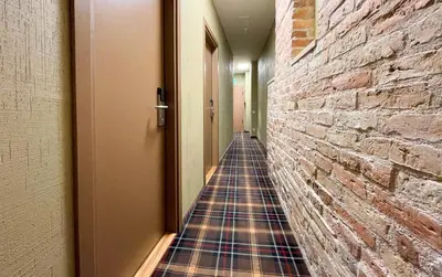 a hallway lined with a brick wall with a kilt at New Town Home 1 in Vilnius