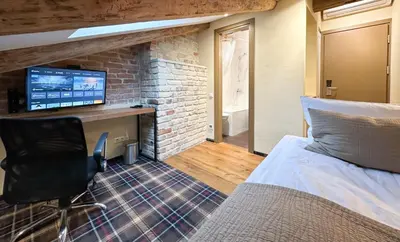 a bedroom with a bed and a desk with a computer at New Town Home 1 in Vilnius