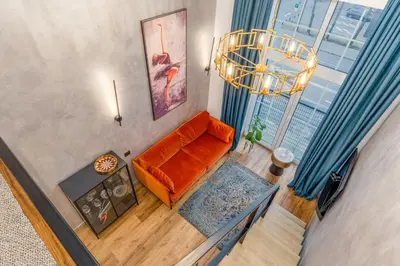 an overhead view of a living room with an orange couch at Petit Retreat Loft by URBAN RENT in Kaunas