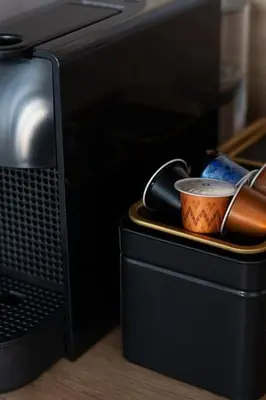 a black box with a cup in front of a computer monitor at Petit Retreat Loft by URBAN RENT in Kaunas