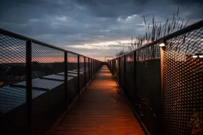 a walkway with a fence on a bridge at Petit Retreat Loft by URBAN RENT in Kaunas