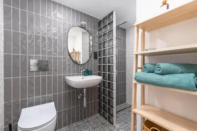 a bathroom with a sink and a toilet and a mirror at Petit Retreat Loft by URBAN RENT in Kaunas