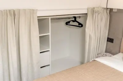 a bedroom with a bed and a curtain at Petit Retreat Loft by URBAN RENT in Kaunas