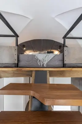 a bunk bed on a table with a bench at EIM apartment in Vilnius