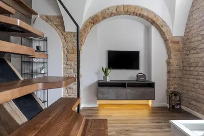 an archway leads into a living room with a television at EIM apartment in Vilnius