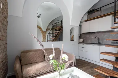 a living room with a couch and a kitchen at EIM apartment in Vilnius