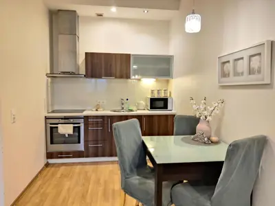 a kitchen with a dining room table and chairs at Pilies VIP apartaments in Vilnius