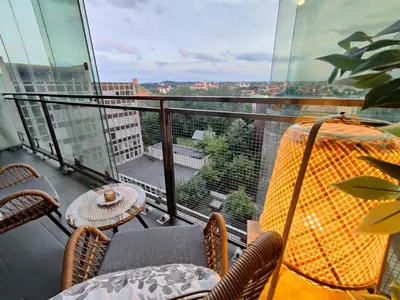 a balcony with a table and chairs and a view at Pilies VIP apartaments in Vilnius