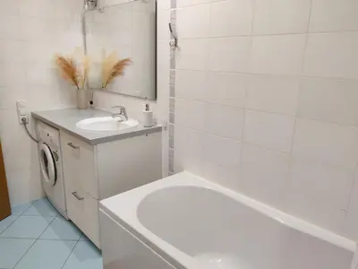 a bathroom with a sink and a washing machine at Pilies VIP apartaments in Vilnius