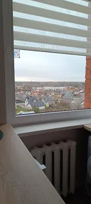 a window with a view of a city from a bedroom at SKY Studio flat in Panevėžys