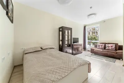 a white bedroom with a bed and a couch at A4 Ozo park apartments in Vilnius