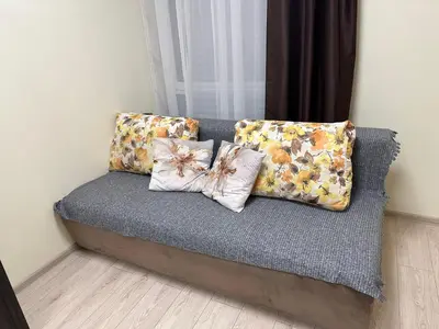 a couch with two pillows on it in a room at A4 Ozo park apartments in Vilnius