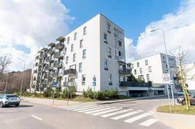a white building on the side of a street at A4 Ozo park apartments in Vilnius