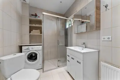 a bathroom with a washing machine and a sink at A4 Ozo park apartments in Vilnius