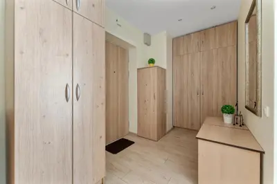an empty room with wooden cabinets and a counter at A4 Ozo park apartments in Vilnius