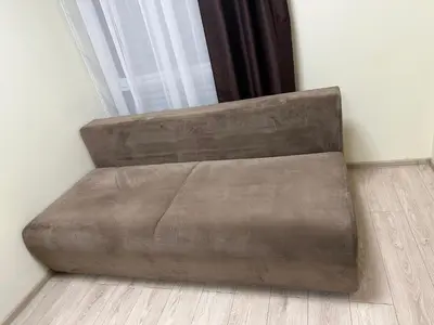 a brown leather couch in a corner of a room at A4 Ozo park apartments in Vilnius