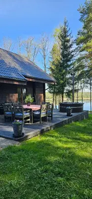 a patio with a table and chairs and a house at Asvejos sodyba in Skirlėnai