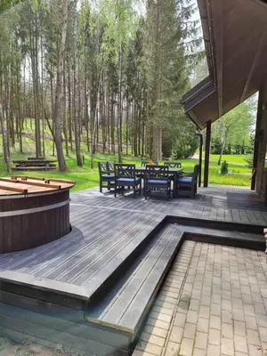 a deck with benches and tables in a park at Asvejos sodyba in Skirlėnai