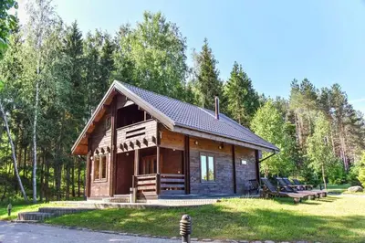 a small log cabin in the middle of a park at Asvejos sodyba in Skirlėnai