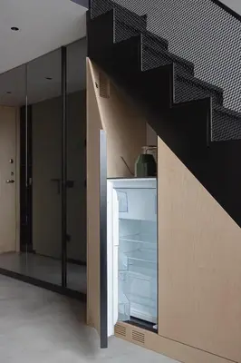 a kitchen with an open refrigerator under a staircase at Stylish Designer Loft in Vilnius Trendiest District in Vilnius