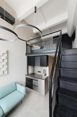 a living room with a staircase and a blue couch at Stylish Designer Loft in Vilnius Trendiest District in Vilnius