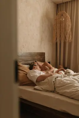 a man and a woman laying on a bed at Wabi-sabi apartamentai in Alytus