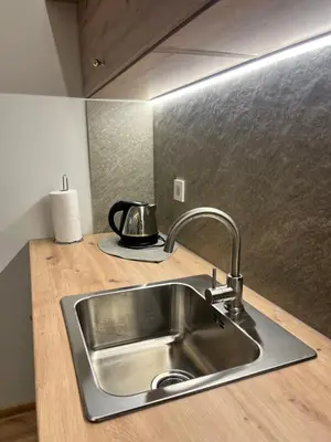 a kitchen counter with a sink and a tea kettle at Beržo Kampelis Mieste in Kaunas