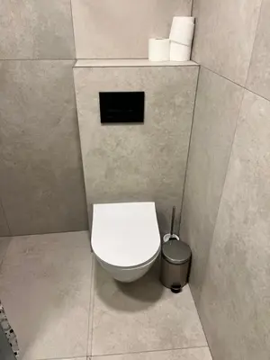 a bathroom with a white toilet and a trash can at Beržo Kampelis Mieste in Kaunas