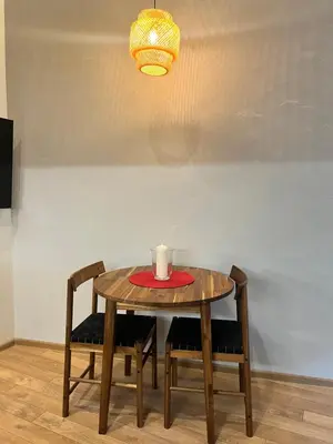 a table with two chairs and a candle on it at Beržo Kampelis Mieste in Kaunas