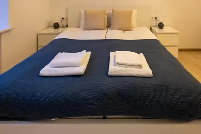 a bed with two towels on top of it at Bright Vilnius Center Apartment in Vilnius