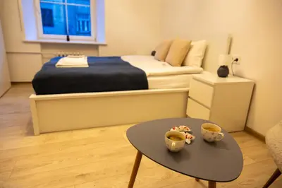 a bedroom with a bed and a table and a bed at Bright Vilnius Center Apartment in Vilnius