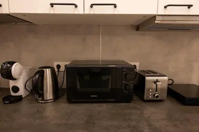 a microwave oven sitting next to a toaster and a blender at Bright Vilnius Center Apartment in Vilnius