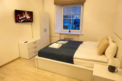 a small bedroom with a bed and a window at Bright Vilnius Center Apartment in Vilnius