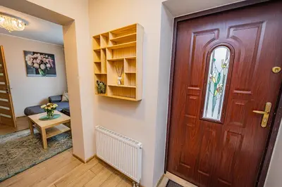 a wooden door in a room with a table at Charming Apartment with Private Yard in Marijampolė