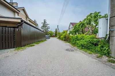 an empty street in a house with a fence at Charming Apartment with Private Yard in Marijampolė