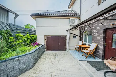 a patio with a table and chairs next to a house at Charming Apartment with Private Yard in Marijampolė