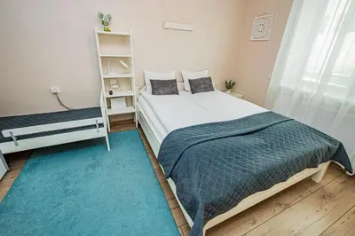 a bedroom with a bed and a book shelf at Charming Apartment with Private Yard in Marijampolė
