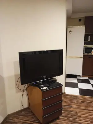 a flat screen tv sitting on a dresser in a room at Butas centre šalia pėsčiųjų bulvaro in Šiauliai
