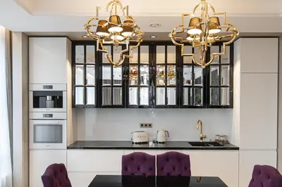 a kitchen with white cabinets and two chandeliers at Basanaviciaus 9 in Vilnius