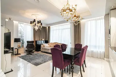 a living room with a glass table and purple chairs at Basanaviciaus 9 in Vilnius