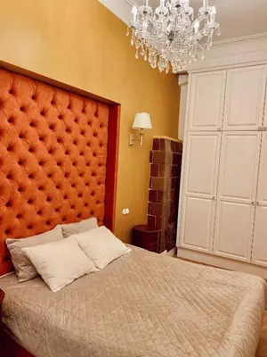 a bedroom with a large bed and a chandelier at Unique apartment in old town in Vilnius