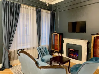 a living room with blue chairs and a fireplace at Unique apartment in old town in Vilnius
