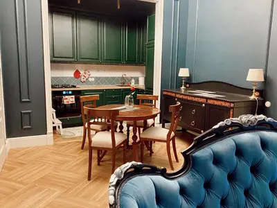 a kitchen with green cabinets and a table and chairs at Unique apartment in old town in Vilnius
