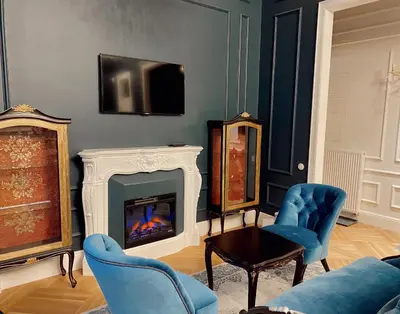 a living room with blue chairs and a fireplace at Unique apartment in old town in Vilnius