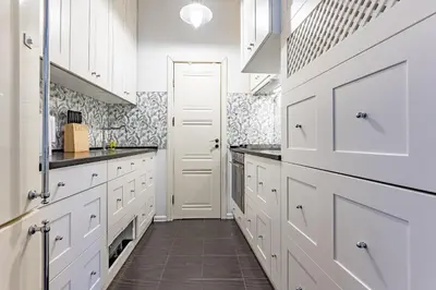 a white kitchen with white cabinets and a tile floor at Next to Cathedral Square, Stylish 2BD Gem, Skapo St in Vilnius