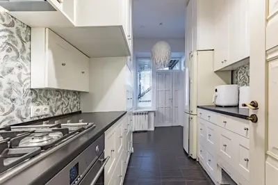 a kitchen with white cabinets and black counter tops at Next to Cathedral Square, Stylish 2BD Gem, Skapo St in Vilnius