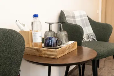 a wooden tray with bottles on a table with chairs at Moja Accommodation in Kaunas