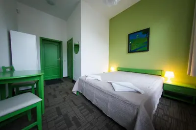 a bedroom with a white bed and green walls at Moja Accommodation in Kaunas
